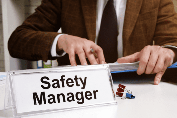 Safety Manager sitting at Desk looking at First aid and CPR OSHA Requirements for the workplace